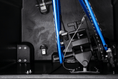Load image into Gallery viewer, Close-up inside the case: a blue bike frame with its rear axle clamped into the VaultLock rear adapter, leaving the chain and derailleur clear.